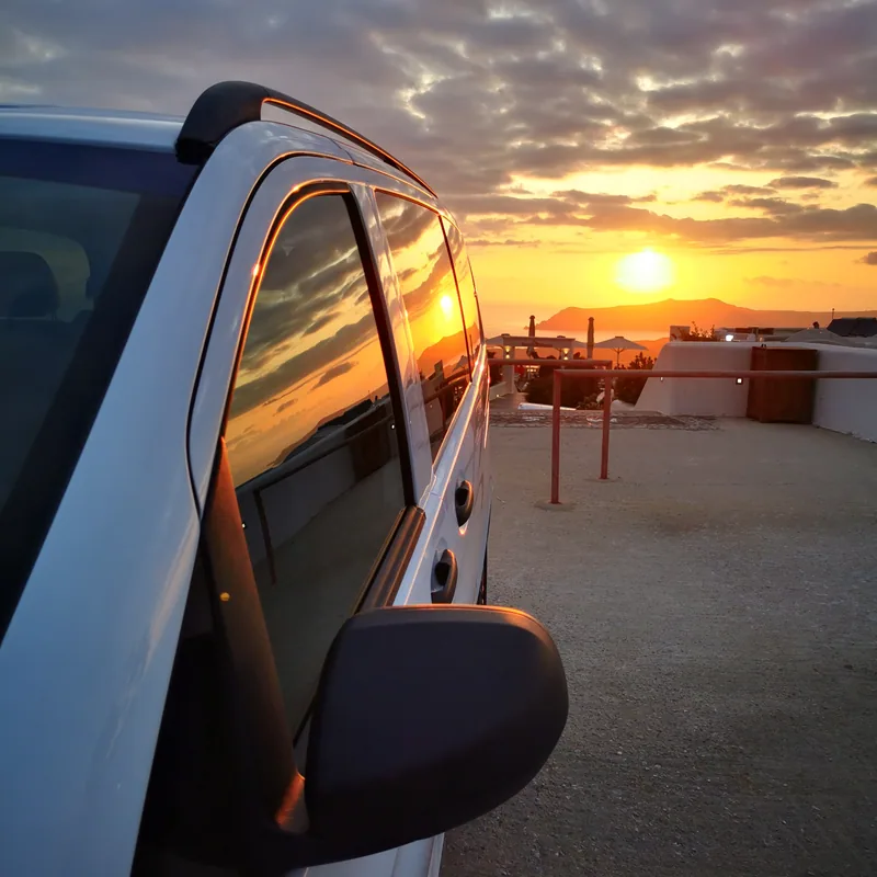 The Santorini sunset reflected in the wing mirror of the van