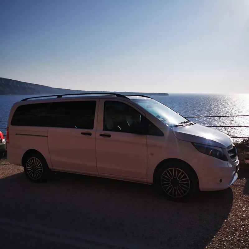 The VH Transfer van waiting at a Santorini pickup point with the caldera behind