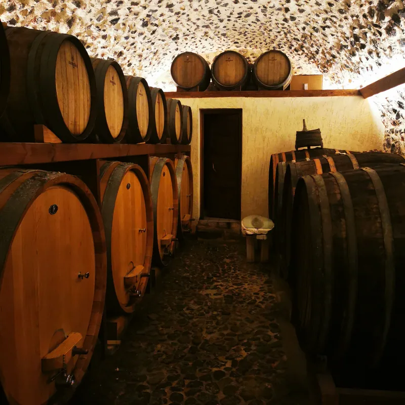 Old wooden barrels inside a traditional Santorini winery